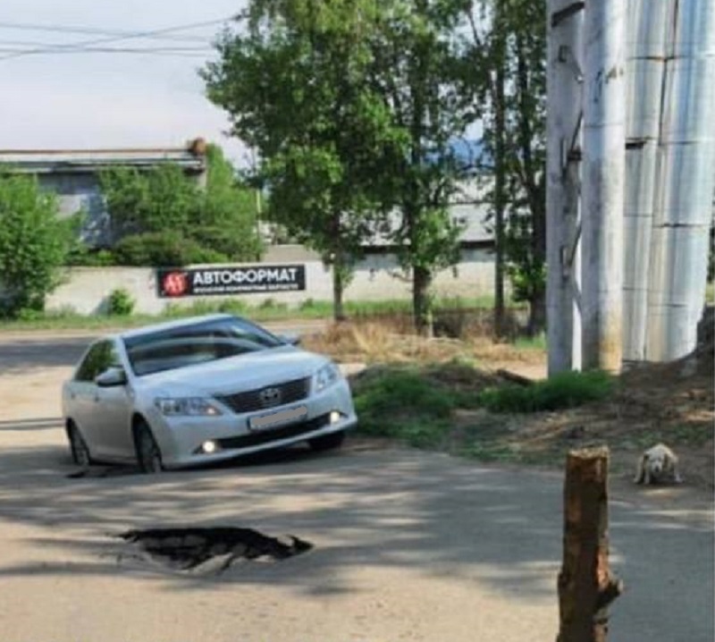 Фото На дороге в Улан-Удэ автомобиль провалился колесами под землю